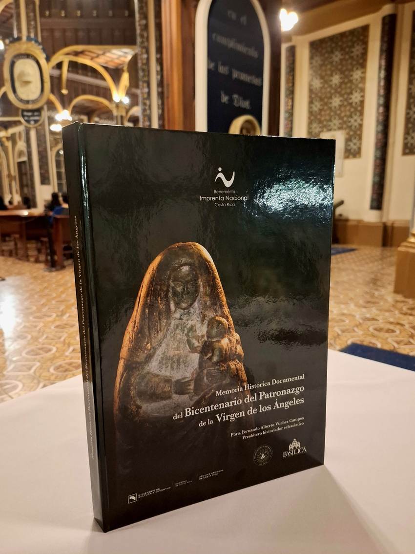 Fotografía del libro Memoria Histórica Documental del Bicentenario de la Virgen de los Ángeles, en la portada aparece la imagen de piedra de la virgen y logotipos de instituciones